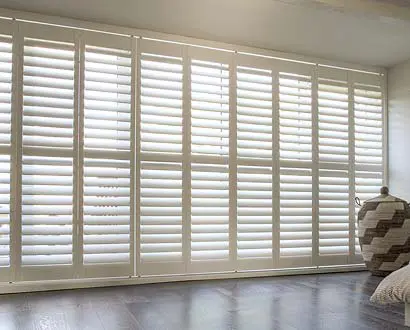 White tracked shutters on very large window