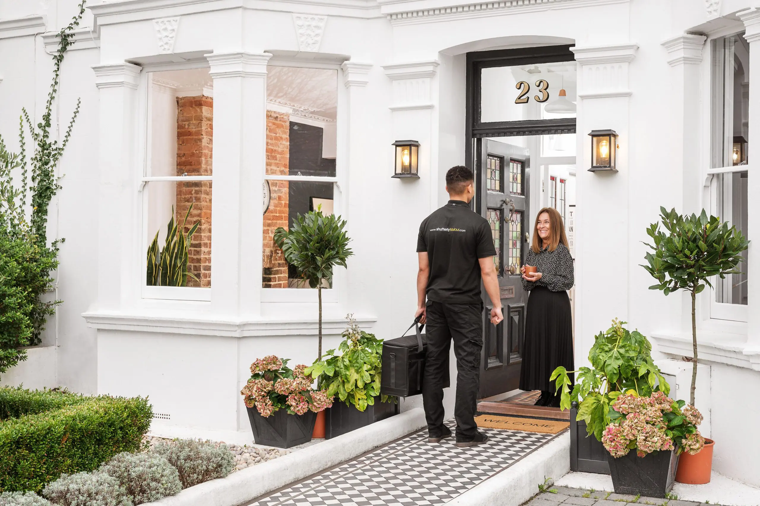 Shutterly fabulous specalist visiting customer for home appointment, at their large white period home.