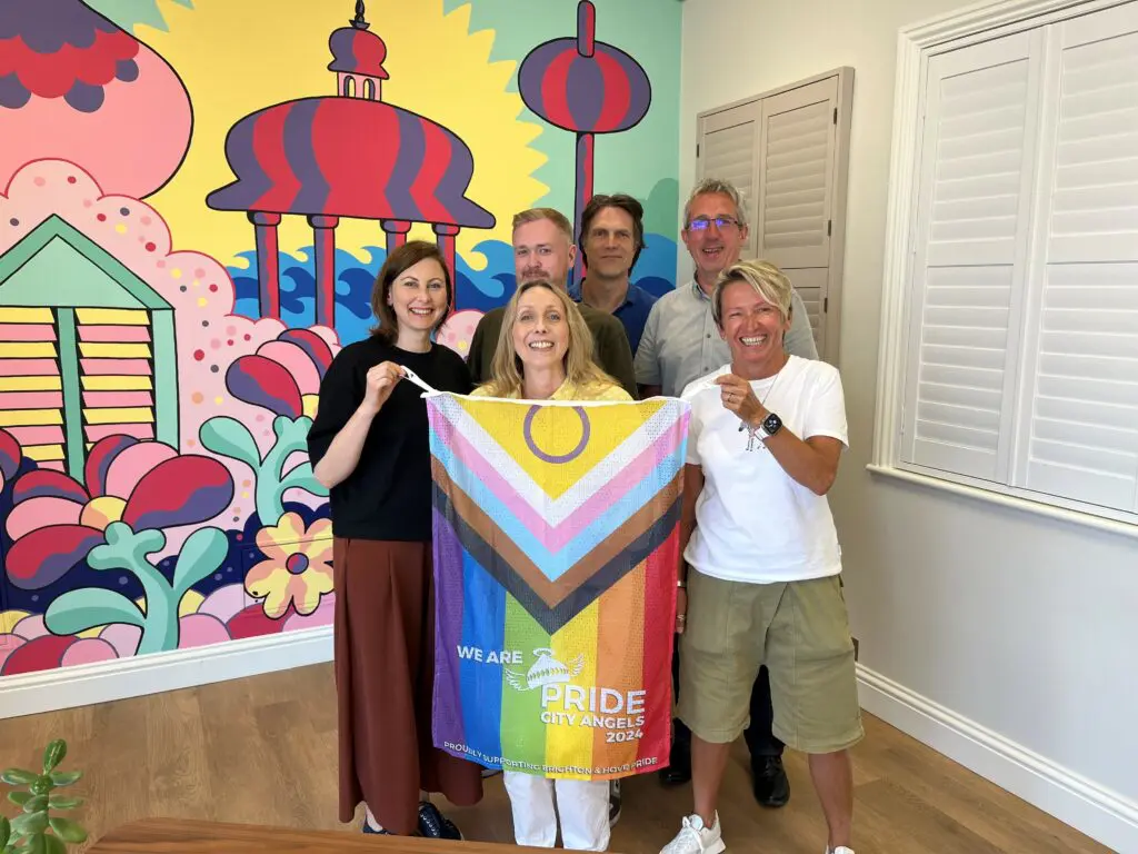 Shutterly Fabulous Team holding up a Pride flag