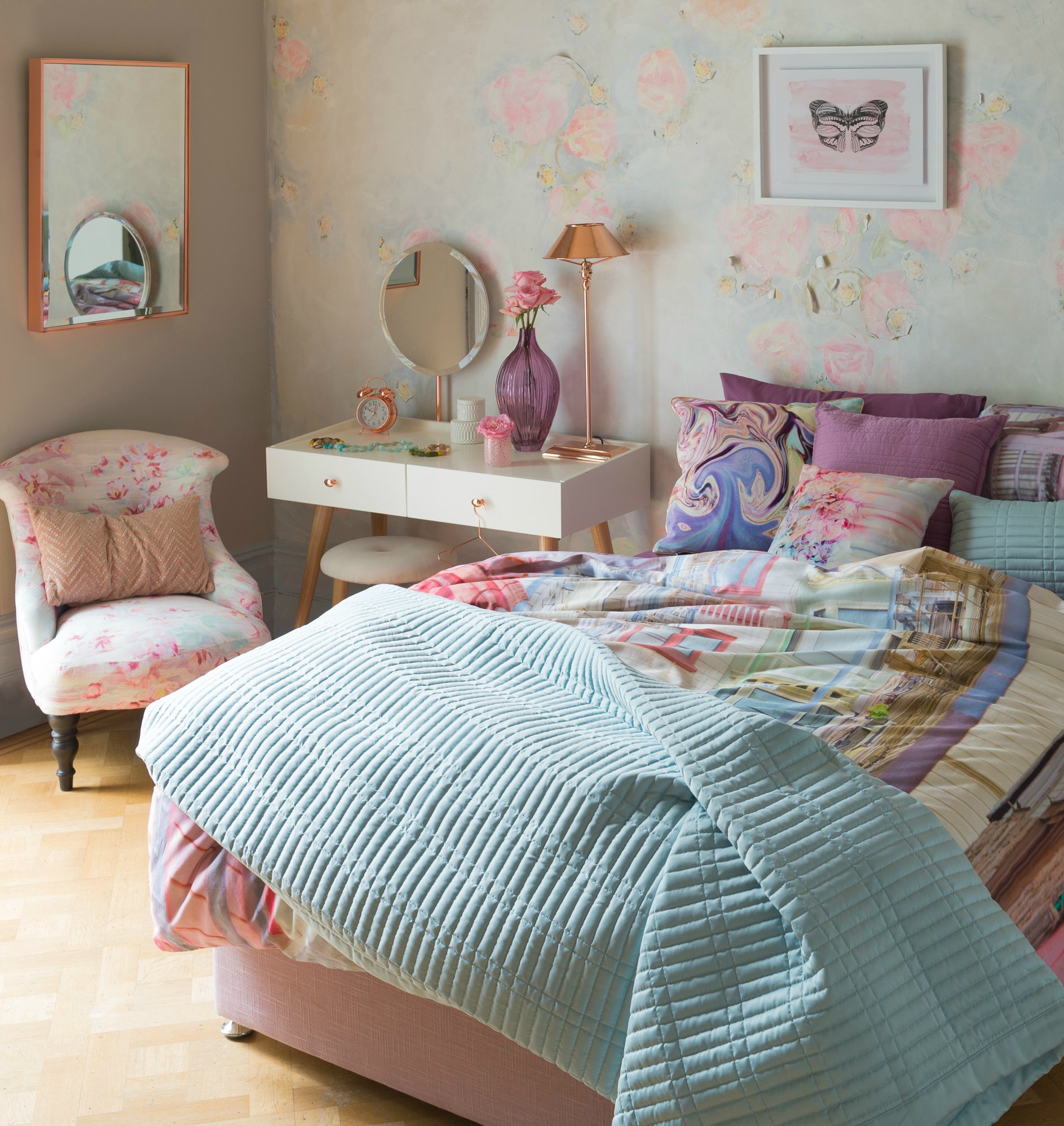 bedroom with colourful bedding and a pink chair