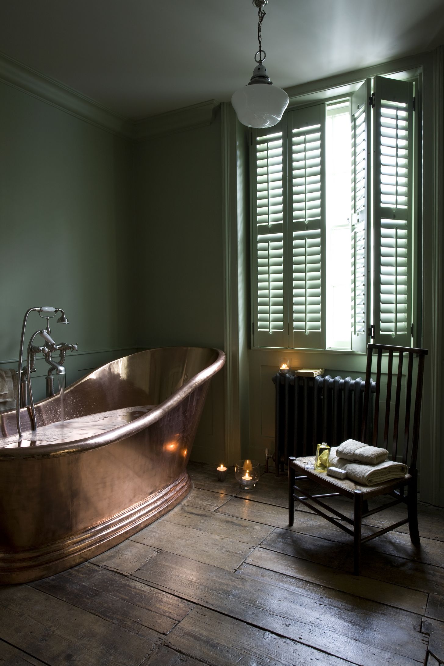 green shutters in bathroom with copper bathtub