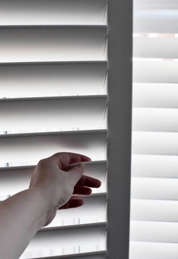 person moving shutter slats 