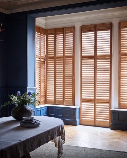 Box bay window shutters wood on dark blue walls