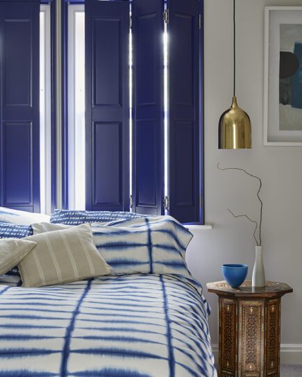Casement window shutters shown in a bedroom