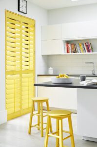 bright yellow full height shutters on kitchen windows
