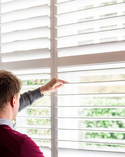 Customer looking through shutter slats