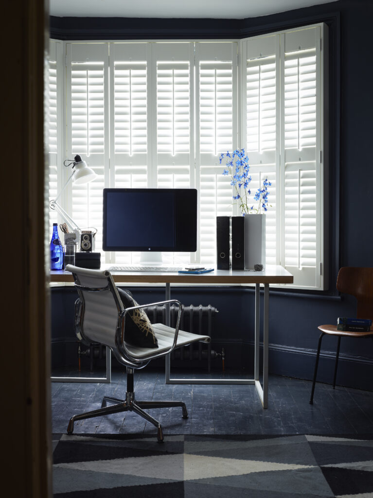 White Bedroom window shutters with a desk, laptop and office chair